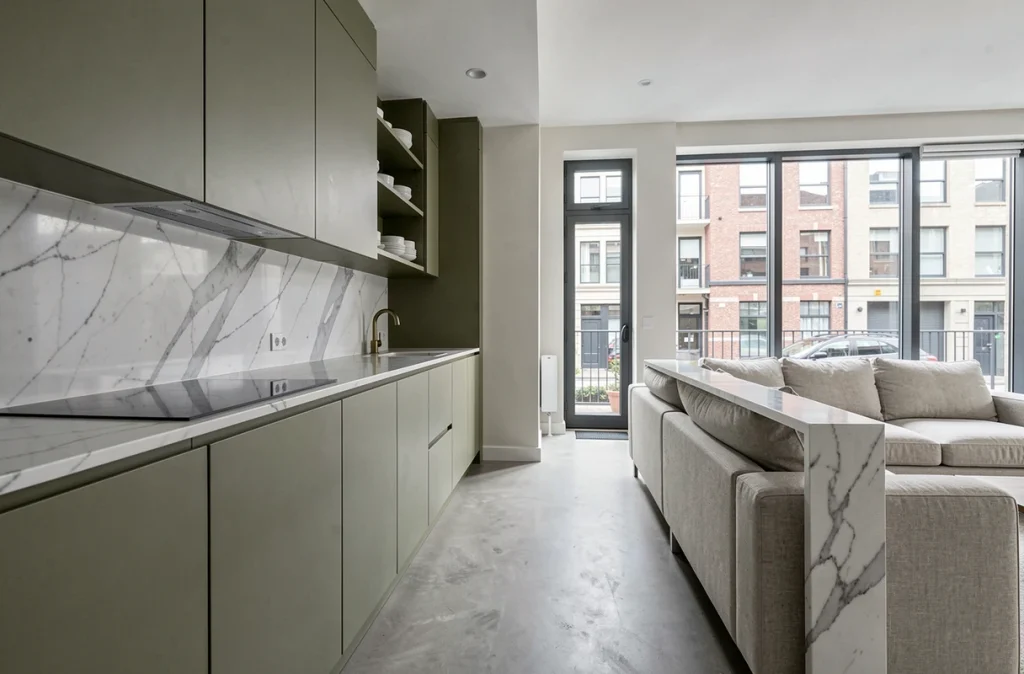 Cuisine ouverte renovee avec ilot en marbre et salon integre dans un appartement moderne